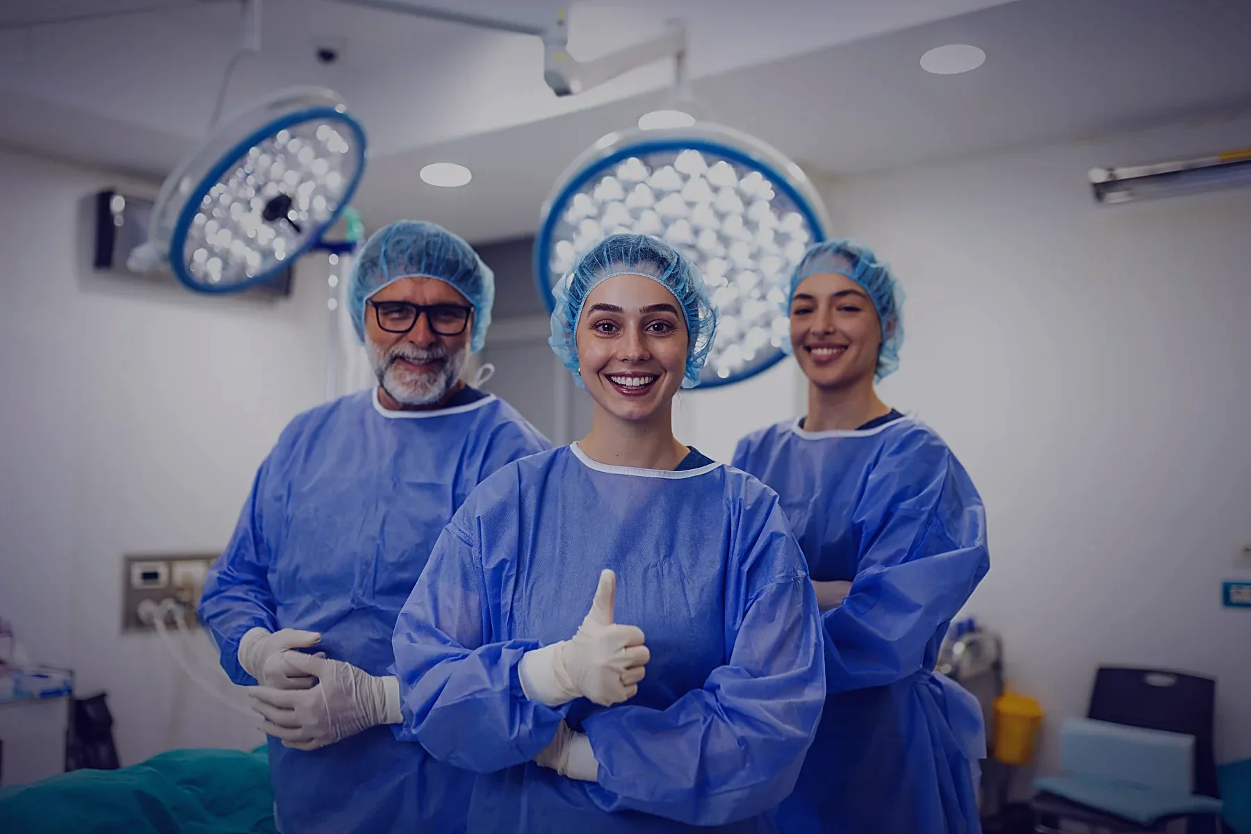A theatre team smiling together under the operating lights